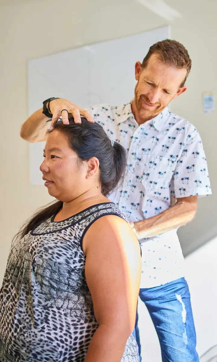 A chiropractor adjusting a woman's neck in a clinic